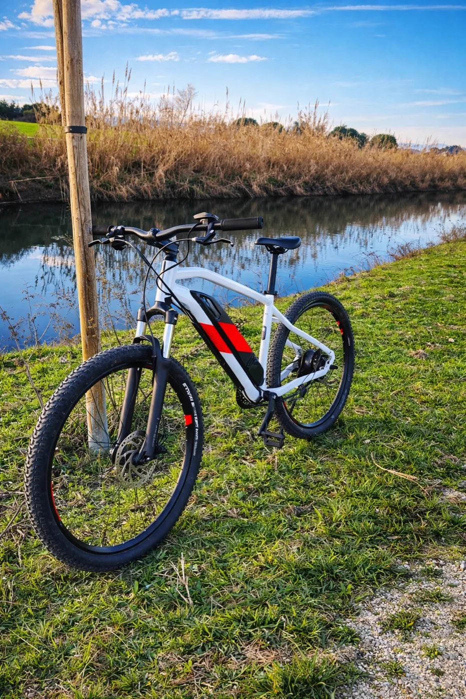 Vélo à assistance électrique au bord d'un canal dans la campagne provençale
